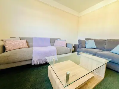 a living room with a couch and a coffee table at 4-Bedroom House 5 mins to Beach & Parking in Felixstowe