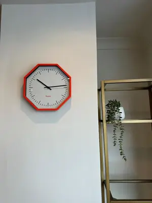 a clock hanging on a wall next to a shelf at 1 bed flat in central Cambridge in Cambridge