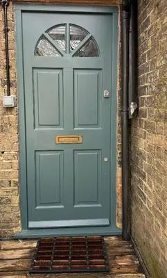 a green door with a window and a brick wall at 1 bed flat in central Cambridge in Cambridge