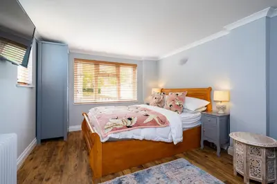 a bedroom with a bed and a window at Holly House Studio, Lavenham in Lavenham