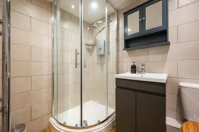 a bathroom with a shower with a sink and a toilet at Holly House Studio, Lavenham in Lavenham