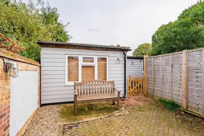 a wooden bench sitting in front of a shed at Holly House Studio, Lavenham in Lavenham