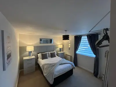 a small bedroom with a bed and a window at stylish two bed Ipswich apartment close to the waterfront sleeps 5 perfect for contractors leisure travel stays in Ipswich