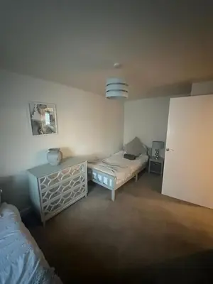 a room with a bed and a table in it at stylish two bed Ipswich apartment close to the waterfront sleeps 5 perfect for contractors leisure travel stays in Ipswich
