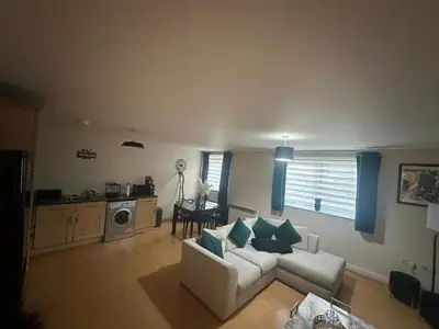 a living room with a white couch and blue pillows at stylish two bed Ipswich apartment close to the waterfront sleeps 5 perfect for contractors leisure travel stays in Ipswich