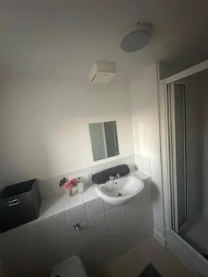 a white bathroom with a sink and a mirror at stylish two bed Ipswich apartment close to the waterfront sleeps 5 perfect for contractors leisure travel stays in Ipswich