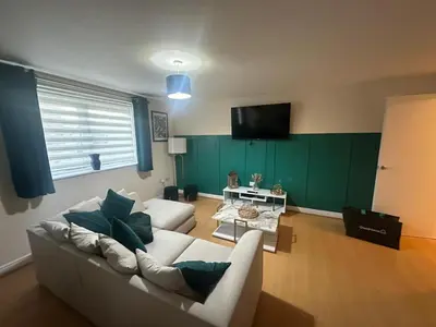 a living room with a white couch and a green wall at stylish two bed Ipswich apartment close to the waterfront sleeps 5 perfect for contractors leisure travel stays in Ipswich