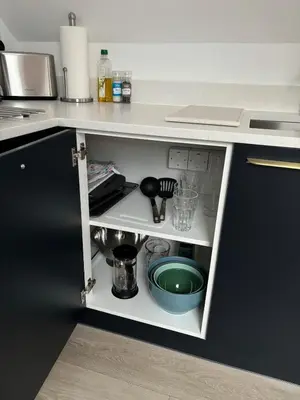a kitchen with a counter with a shelf with dishes at The Cartlodge - Studio Loft Apartment in Horringer, Bury St Edmunds in Westley