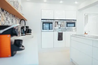 a white kitchen with white cabinets and appliances at 5 Bed Family Home- Free Parking in Woodham Ferrers Station
