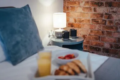 a plate of food and a bowl of fruit on a bed at 5 Bed Family Home- Free Parking in Woodham Ferrers Station