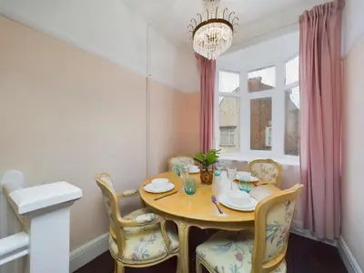 a dining room with a table and chairs and a window at 2 Bed Apartment- Leigh Broadway in Southend-on-Sea