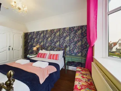 two beds in a room with a wall mural at 2 Bed Apartment- Leigh Broadway in Southend-on-Sea