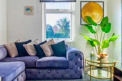 a purple couch in a living room with a window at Rayleigh Retreat-Spacious Family 3 Bed Apartment in Rayleigh