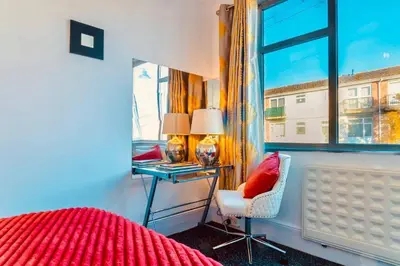 a bedroom with a bed and a desk and a window at Rayleigh Retreat-Spacious Family 3 Bed Apartment in Rayleigh