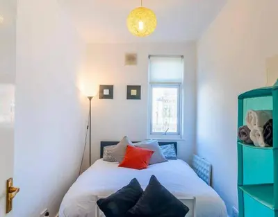 a bedroom with a bed with a red pillow at Rayleigh Retreat-Spacious Family 3 Bed Apartment in Rayleigh