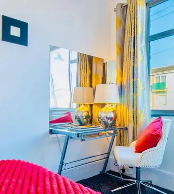 a bedroom with a desk with two lamps and a chair at Rayleigh Retreat-Spacious Family 3 Bed Apartment in Rayleigh