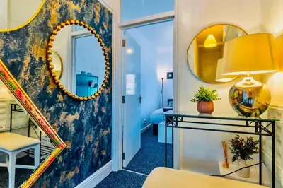 a room with a staircase and a mirror at Rayleigh Retreat-Spacious Family 3 Bed Apartment in Rayleigh