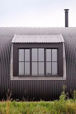 a window on the side of a black building at Converted Nissen Barn on beautiful farm in Braintree