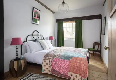 a bedroom with a bed and a window at Farmhouse in Suffolk with wild swimming & hot tub in Saint Margaret