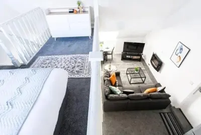 a living room with a couch and a bed at 1 Bed Split Level Apartment- Leigh-on-Sea in Southend-on-Sea