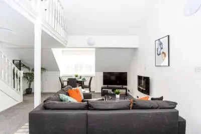 a living room with a couch and a tv at 1 Bed Split Level Apartment- Leigh-on-Sea in Southend-on-Sea