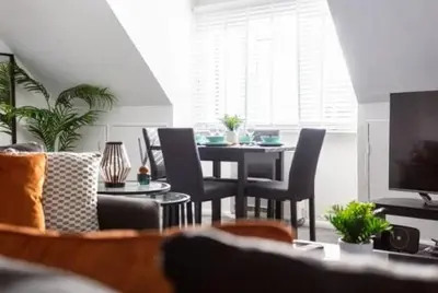 a living room with a dining room table and chairs at 1 Bed Split Level Apartment- Leigh-on-Sea in Southend-on-Sea