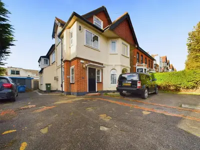 a house with a car parked in a parking lot at Westcliff apartment with free parking in Southend-on-Sea