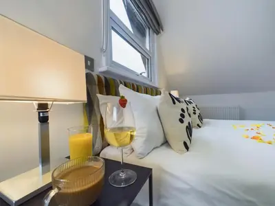 a bedroom with a bed with a glass of wine at Westcliff apartment with free parking in Southend-on-Sea