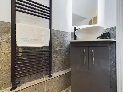 a bathroom with a sink and a mirror at Westcliff apartment with free parking in Southend-on-Sea