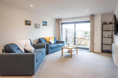 a living room with two blue couches and a table at Grove Farm Cottage, Worlingworth in Worlingworth