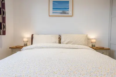 a bedroom with a bed with two lamps on tables at Grove Farm Cottage, Worlingworth in Worlingworth