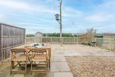 a patio with a table and chairs and a fence at Grove Farm Cottage, Worlingworth in Worlingworth