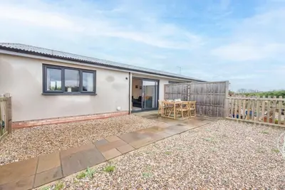 a house with a patio and a wooden fence at Grove Farm Cottage, Worlingworth in Worlingworth