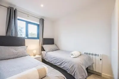 a bedroom with two beds with a stuffed animal on it at Grove Farm Cottage, Worlingworth in Worlingworth