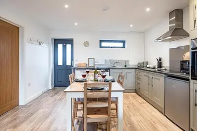 a kitchen with a table with wine glasses on it at Grove Farm Cottage, Worlingworth in Worlingworth