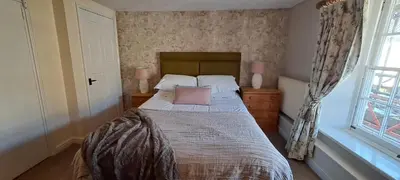 a bedroom with a bed with two pillows and a window at Earsham Street House in Bungay