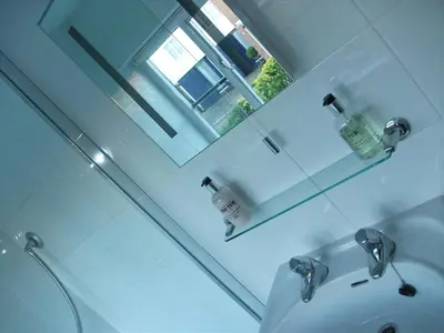 a white bathroom with a mirror and a sink at Earsham Street House in Bungay