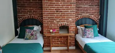 two beds in a room with a brick wall at Earsham Street House in Bungay