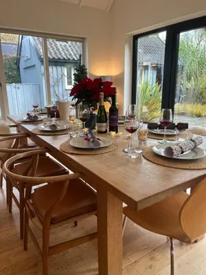 a wooden table with wine glasses and wine bottles at Charming Cottage nestled in the heart of a picturesque village in Westleton