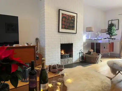 a living room with two bottles of wine and a fireplace at Charming Cottage nestled in the heart of a picturesque village in Westleton
