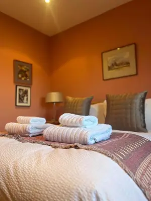 a group of towels sitting on top of a bed at Charming Cottage nestled in the heart of a picturesque village in Westleton