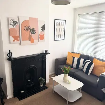 a living room with a couch and a fireplace at Cosy Home in Chelmsford City, Free WiFi & Free Parking - Mildmay House by Stays Accommodation - Long Stays Welcome in Chelmsford