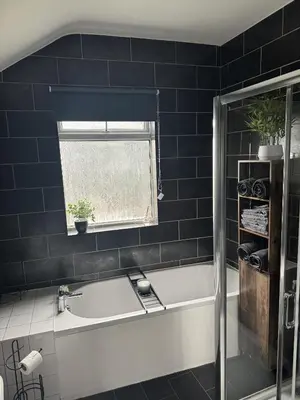 a bathroom with a bath tub and a window at Cosy Home in Chelmsford City, Free WiFi & Free Parking - Mildmay House by Stays Accommodation - Long Stays Welcome in Chelmsford