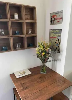 a vase of flowers sitting on a wooden table at Outbuilding with river views in Cambridgeshire in Holywell