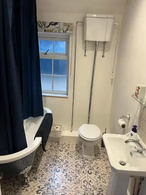 a bathroom with a toilet and a tub and a sink at Outbuilding with river views in Cambridgeshire in Holywell