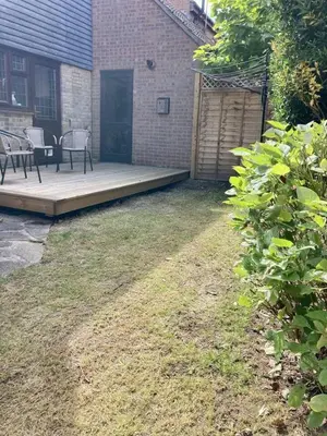 a backyard with a deck with two chairs and a table at Brackens House Brentwood in Little Warley