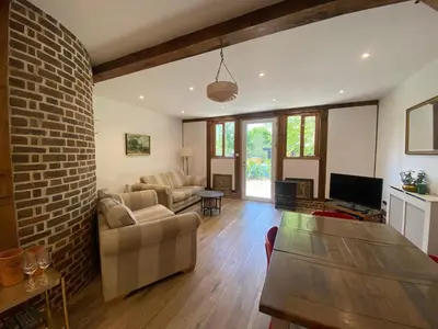 a living room with a couch and a brick wall at Charming 2-Bedroom Cottage in Cambridgeshire in West Wratting