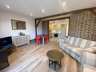 a living room with a couch and a brick wall at Charming 2-Bedroom Cottage in Cambridgeshire in West Wratting