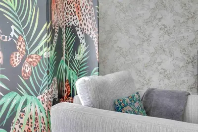 a living room with a couch and a wall mural at Elizabeth Four Bedroom Townhouse in Bocking Churchstreet