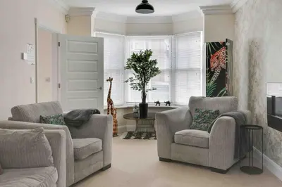 a living room with two chairs and a couch at Elizabeth Four Bedroom Townhouse in Bocking Churchstreet